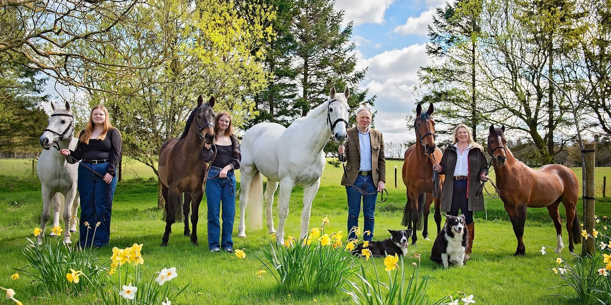 Paul, Angela, Emily and Annabelle with their horses in the field with daffodils