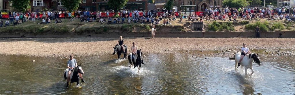 Appleby Horse Fair — riders crossing the River Eden with crowds watching from the bank